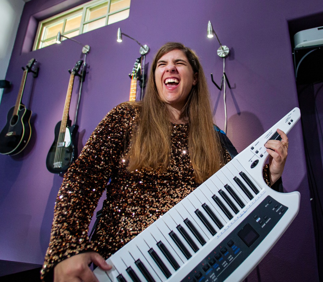 Jazz standing behind keyboard piano smiling